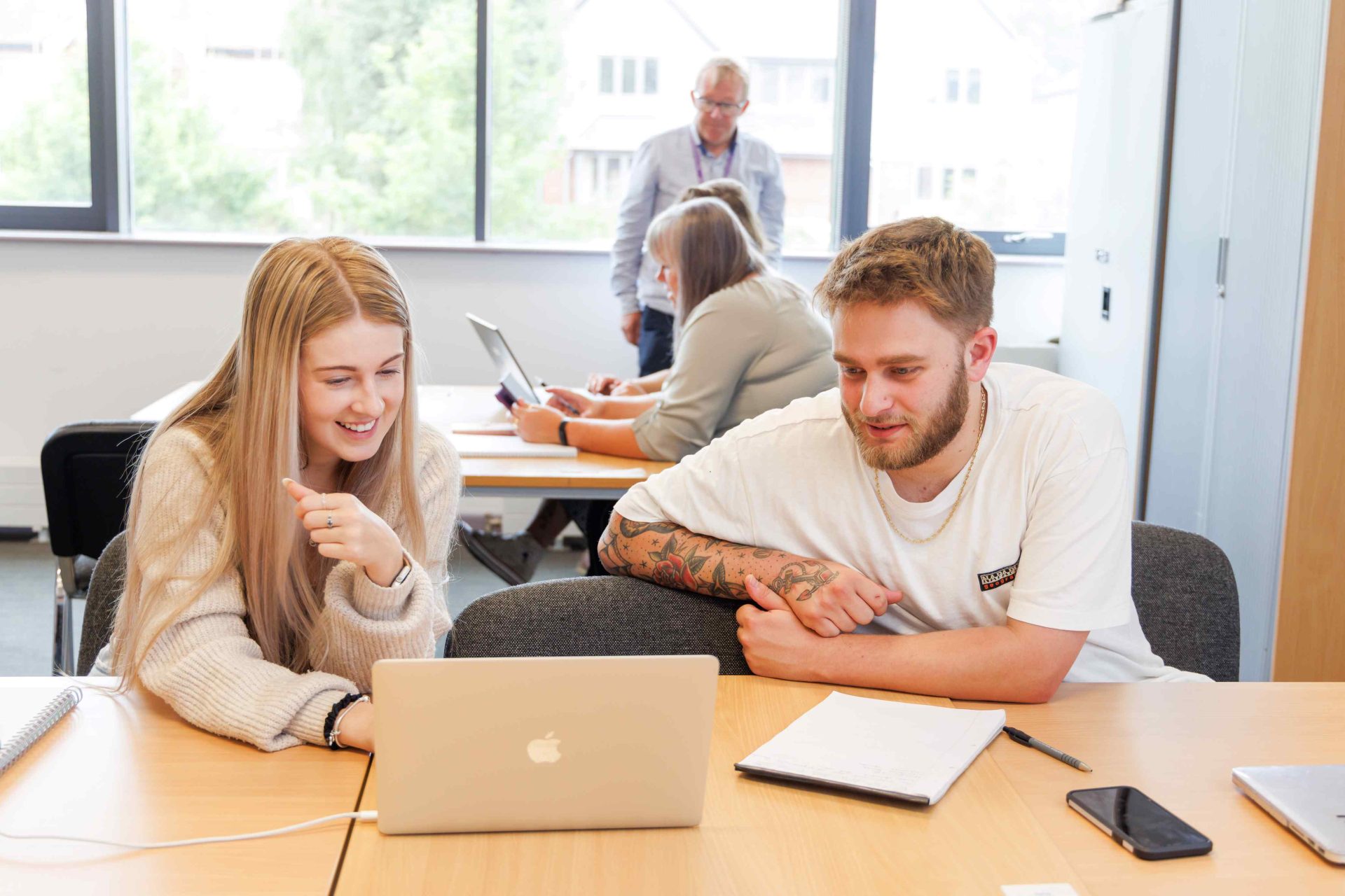 young woman and young man in classroom on laptop